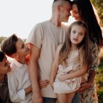 Family enjoying quality time together outdoors by the lake during sunset.